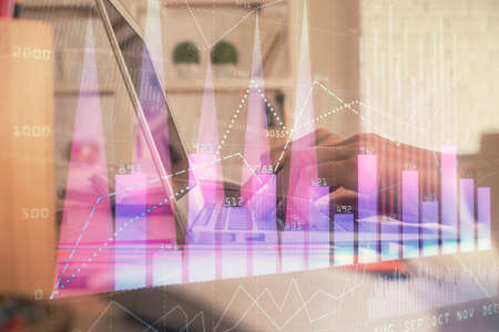 Double exposure of woman hands typing on computer and forex chart hologram drawing. Stock market...
