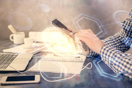 Double exposure of mans hands holding and using a phone and crypto currency blockchain theme...