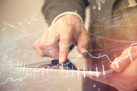 Multi exposure of mans hands holding and using a phone and financial chart drawing. Market analysis...