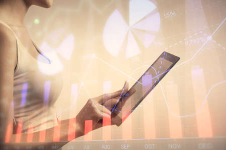 Double exposure of forex chart sketch hologram and woman holding and using a mobile device....