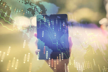 Double exposure of forex chart sketch hologram and woman holding and using a mobile device....