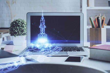 Desktop computer background in office and start up theme hologram drawing. Double exposure. Startup...