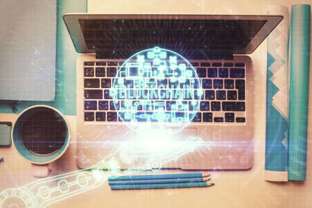 Blockchain theme hologram drawings over computer on the desktop background. Top view. Multi exposure. Concept of cryptoeconomy.の写真素材