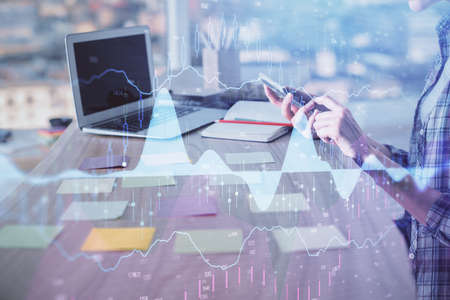 Double exposure of woman hands working on computer and forex graph hologram drawing. Financial...