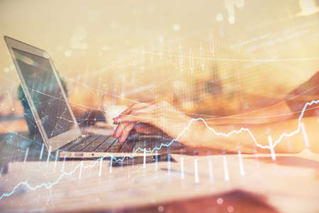 Double exposure of businesswoman hands typing on computer and forex chart hologram drawing....
