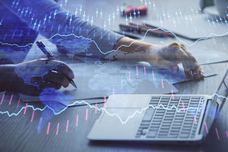 Double exposure of businesswoman hands typing on computer and forex chart hologram drawing....