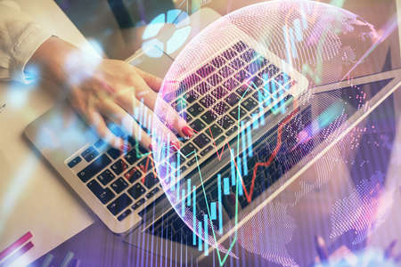 Double exposure of woman hands typing on computer and financial graph hologram drawing. Stock market analysis concept.の写真素材