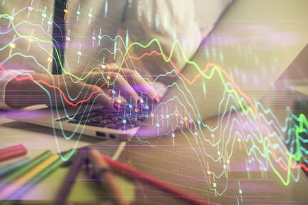 Double exposure of woman hands typing on computer and financial graph hologram drawing. Stock market...