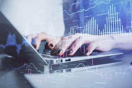 Double exposure of woman hands typing on computer and forex chart hologram drawing. Stock market...
