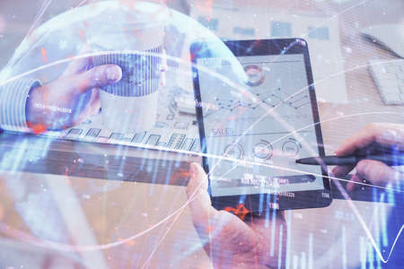 Double exposure of mans hands holding and using a phone and financial chart drawing. Market analysis...