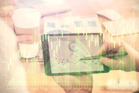 Double exposure of mans hands holding and using a phone and financial chart drawing. Market analysis...