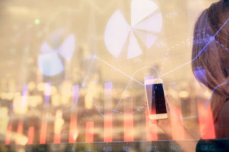 Double exposure of forex chart sketch hologram and woman holding and using a mobile device. Stock...
