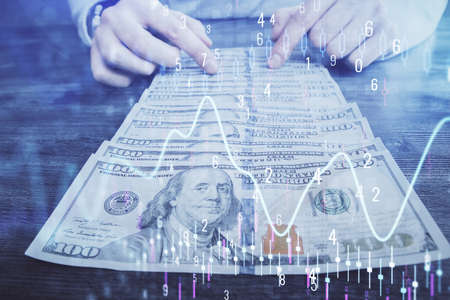 Multi exposure of forex graph drawing hologram and USA dollars bills and man hands. Technical...