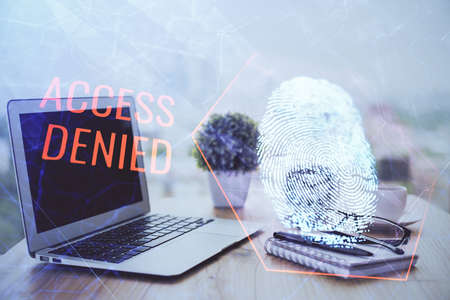 Computer on desktop in office with finger print drawing. Double exposure. Concept of business data security.の写真素材
