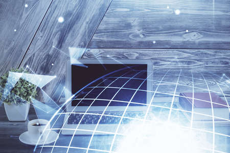 Double exposure of desktop with computer and world map hologram. International data network concept.
