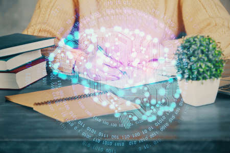Multi exposure of writing hand on background with brain hologram. Concept of learning.