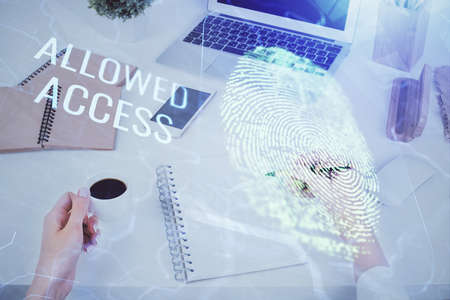Blue fingerprint hologram over womans hands taking notes background. Concept of protection. Double...