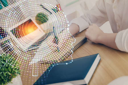 Multi exposure of writing hand on background with brain hologram. Concept of learning.の写真素材