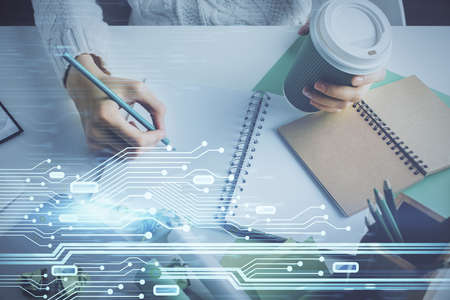 Double exposure of hands making notes background with technology and digital coding huds. Data...