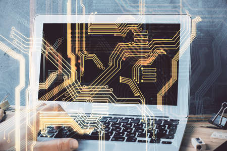 Technology theme hologram with man working on computer on background. High tech concept. Multi...