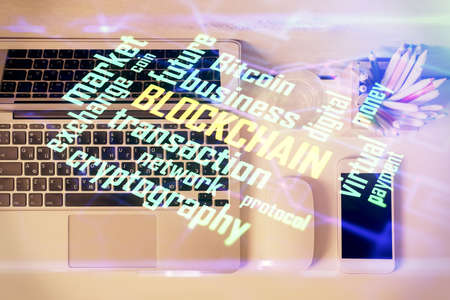 Blockchain theme hologram drawings over computer on the desktop background. Top view. Multi exposure. Concept of cryptoeconomy.の写真素材