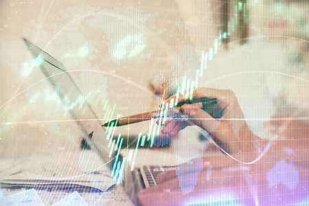 Multi exposure of woman hands typing on computer and financial graph hologram drawing. Stock market...
