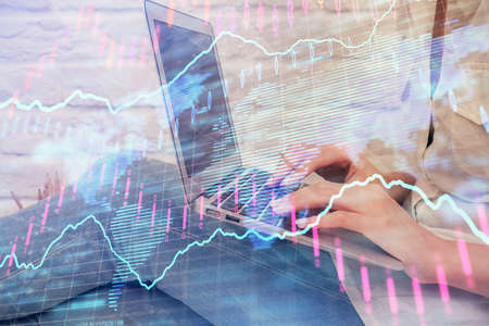 Multi exposure of woman hands typing on computer and forex chart hologram drawing. Stock market...