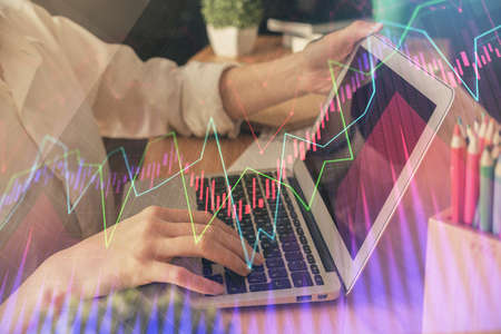 Double exposure of woman hands typing on computer and forex chart hologram drawing. Stock market...