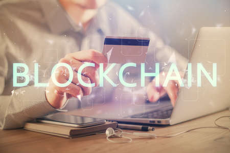 Double exposure of man hands holding a credit card and crypto business theme drawing. Digital...