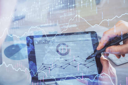 Double exposure of mans hands holding and using a phone and financial chart drawing. Market analysis...