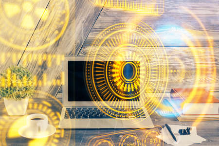 Computer on desktop in office with technology theme hologram. Double exposure. Tech concept.