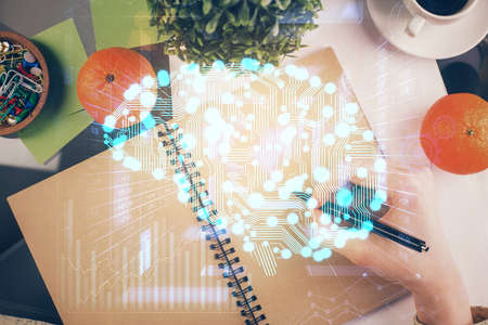 Double exposure of writing hand on background with brain hologram. Concept of learning.の写真素材