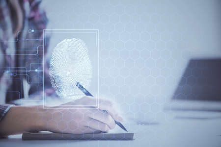 Blue fingerprint hologram over womans hands taking notes background. Concept of protection. Double...