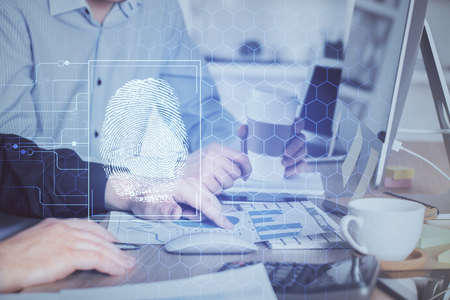 Fingerprint hologram with businessman working on computer on background. Security concept. Double...