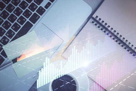 Stock market graph and top view computer on the table background. Double exposure. Concept of financial education.の写真素材
