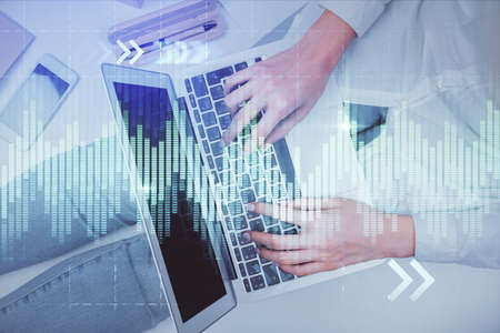 Double exposure of woman hands working on computer and forex graph hologram drawing. Top View....