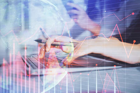 Multi exposure of woman hands typing on computer and financial graph hologram drawing. Stock market...