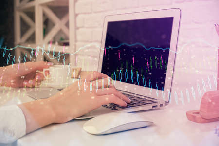 Double exposure of woman hands typing on computer and forex chart hologram drawing. Stock market...