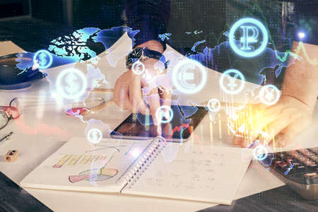 Double exposure of mans hands holding and using a digital device and forex graph drawing. Financial...