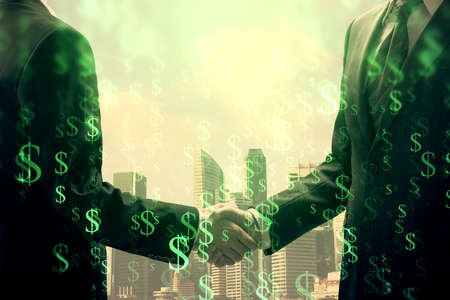 Double exposure of forex graph hologram and handshake of two men. Stock market concept.の写真素材