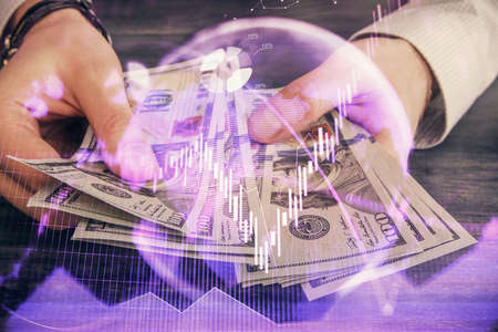 Multi exposure of financial graph drawing hologram and USA dollars bills and man hands. Analysis concept.の写真素材