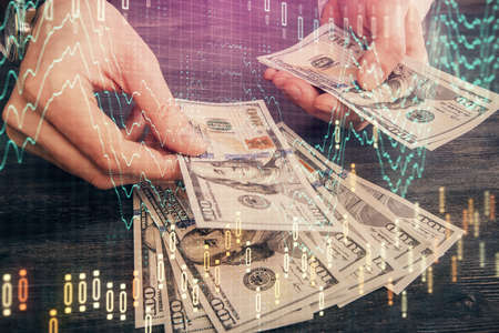 Multi exposure of financial graph drawing hologram and USA dollars bills and man hands. Analysis...