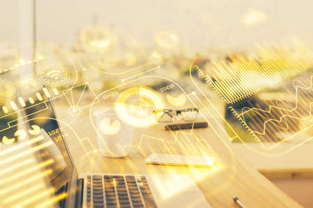 Computer on desktop in office with technology theme hologram. Double exposure. Tech concept.