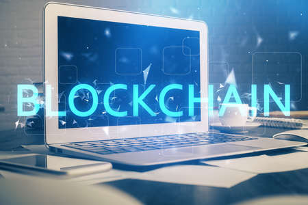 Multi exposure of blockchain theme hologram and table with computer background. Concept of bitcoin crypto currency.の写真素材