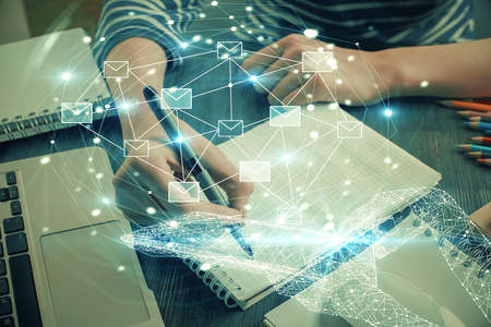 E-mail abstract envelop drawing over hands taking notes background. Concept of electronic mail. Double exposureの写真素材
