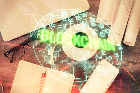 Blockchain theme hologram drawings over computer on the desktop background. Top view. Multi exposure. Concept of cryptoeconomy.の写真素材