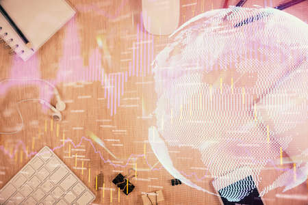 Multi exposure of forex graph hologram over desktop with phone. Top view. Mobile trade platform...