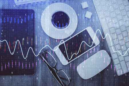 Multi exposure of forex graph hologram over desktop with phone. Top view. Mobile trade platform...