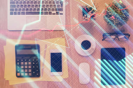 Double exposure of forex chart hologram over desktop with phone. Top view. Mobile trade platform concept.の写真素材