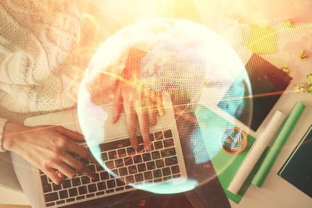 Double exposure of woman hands working on computer and financial theme hologram drawing. Top View. Business concept.の写真素材
